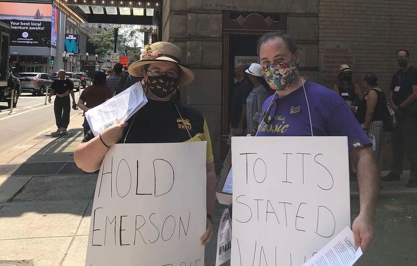 Two Emerson Union members with signs that, when put together, read, "Hold Emerson to its Stated Values".
